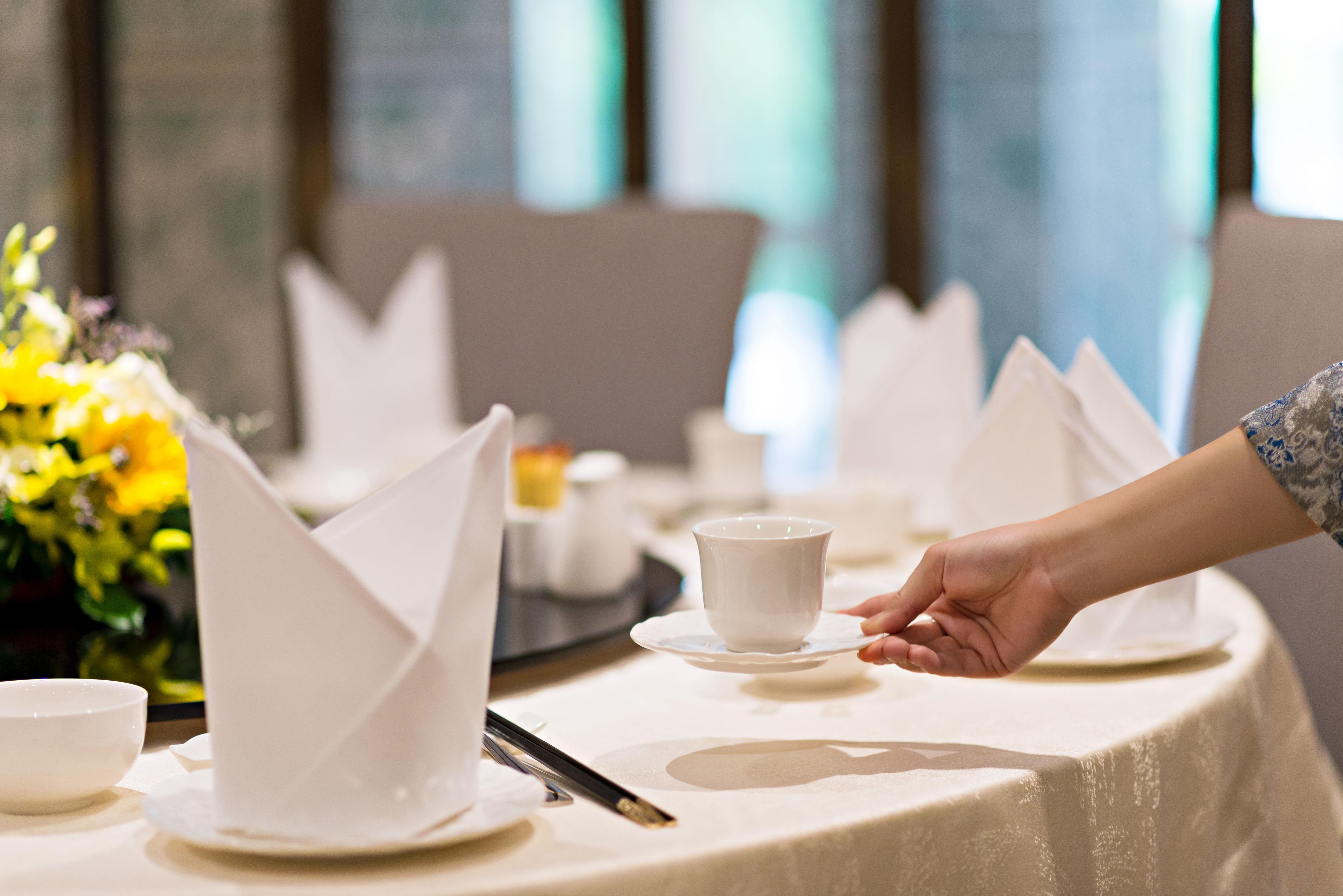 Eastin Grand Hotel Saigon Хошимин Экстерьер фото A server sets a table at a restaurant.